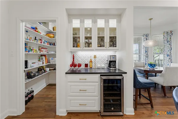 a dining room with furniture a chandelier and wooden floor