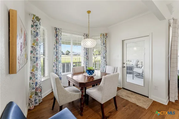 a dining room with furniture a chandelier and wooden floor