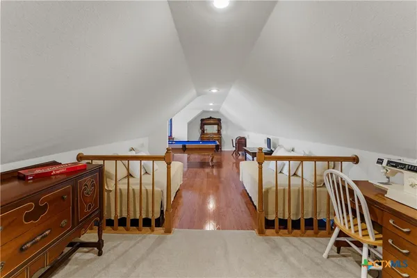 a room with pool table and wooden floor