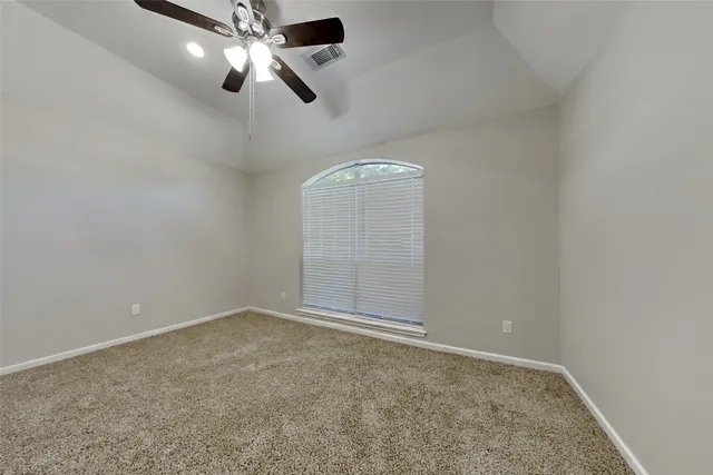 an empty room with chandelier fan