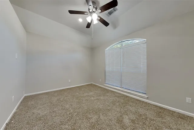 an empty room with chandelier fan