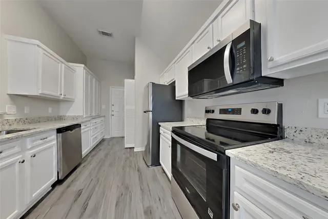 a kitchen with stainless steel appliances granite countertop a stove microwave and sink