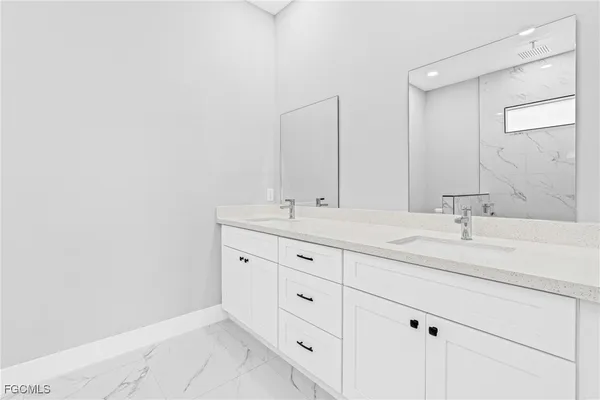 a bathroom with double sink and a mirror