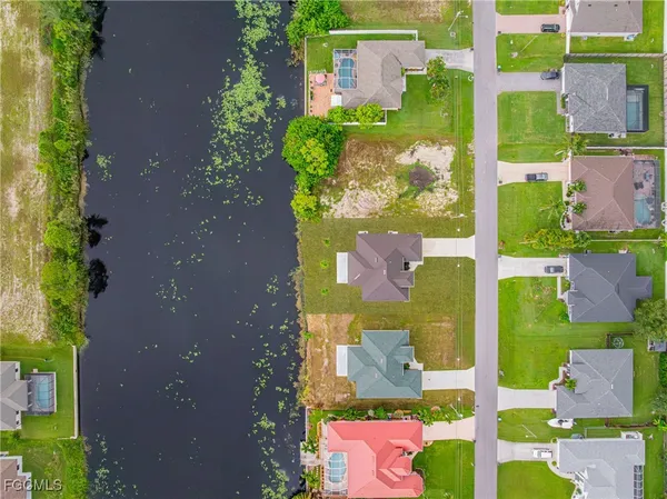 a view of a house with a yard and lake view