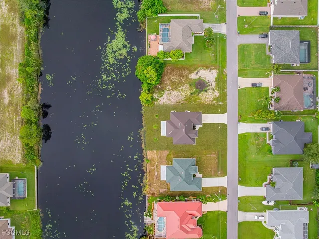 a view of a house with a yard and lake view