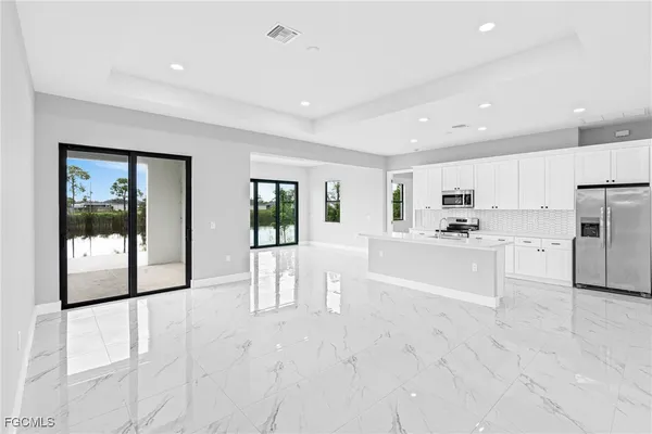 a large white kitchen with white cabinets and stainless steel appliances