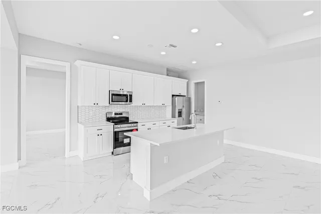 a large white kitchen with stainless steel appliances