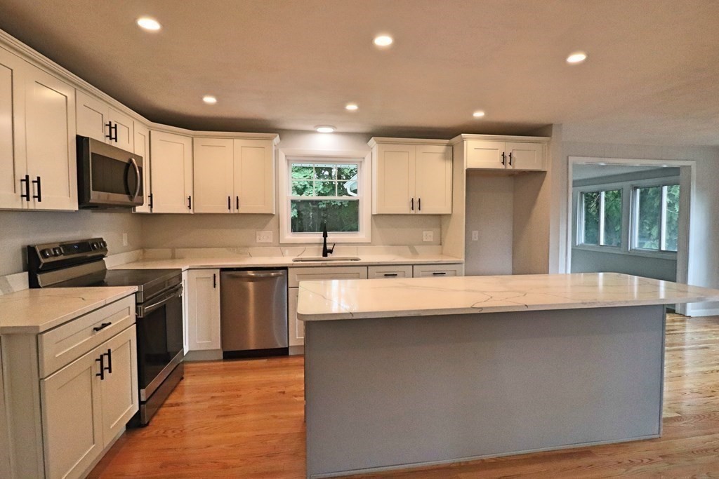 10 Richard Road Hudson, MA 01749 - Photo 8 of 42 a kitchen with stainless steel appliances granite countertop a sink and a stove top oven