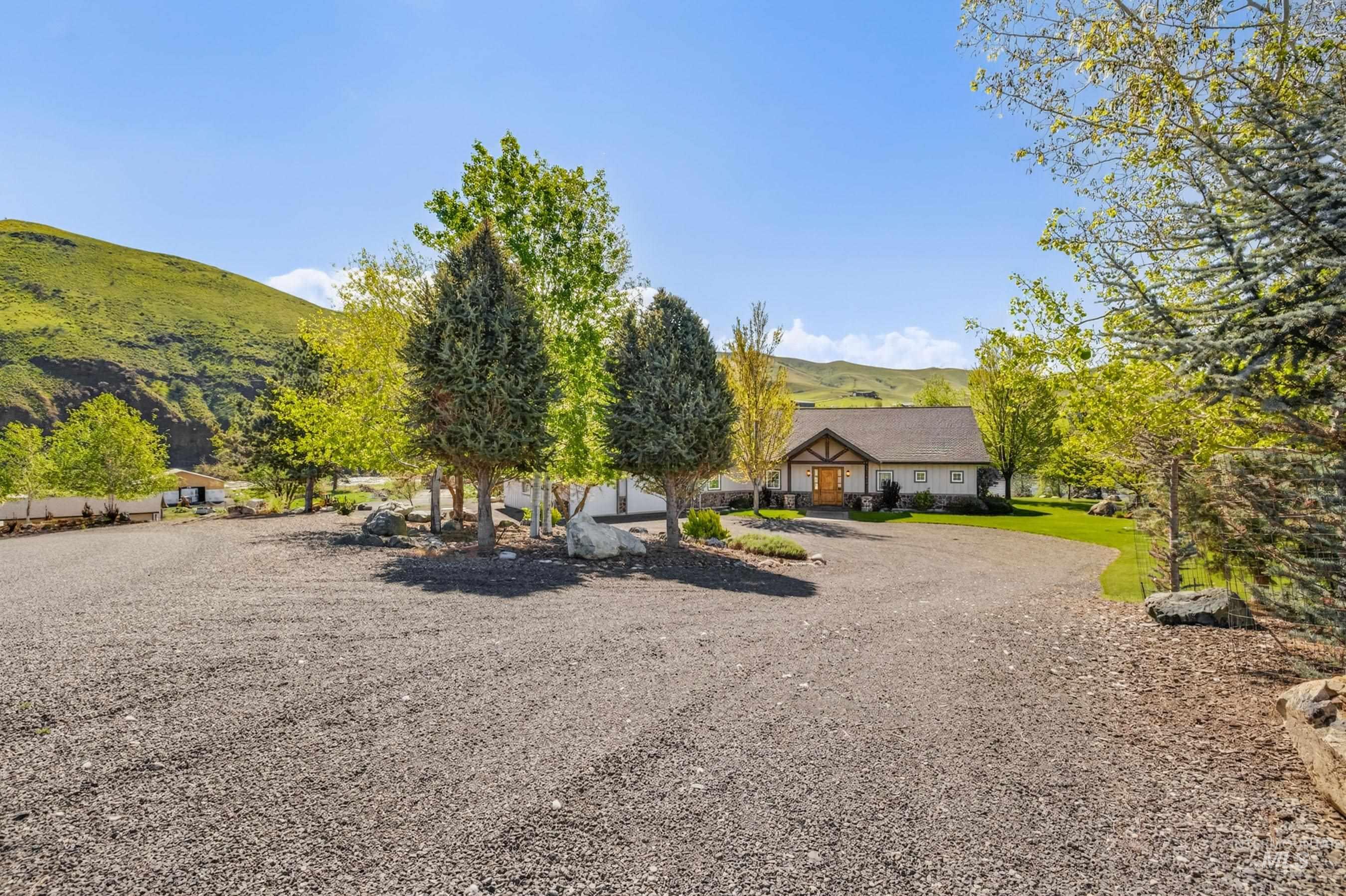 113 Deford Road White Bird, ID 83554 - Photo 41 of 49 Spacious gravel driveway offering ample parking, surrounded by mature trees and natural rock landscaping