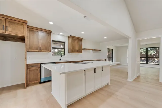 a large kitchen with stainless steel appliances granite countertop a stove a sink and a refrigerator