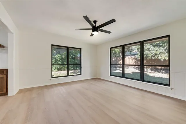 a view of a big room with wooden floor and windows