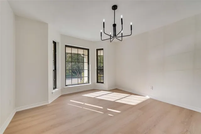 a view of empty room with windows and ceiling fan