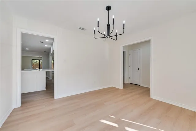 a view of a room with wooden floor and chandelier