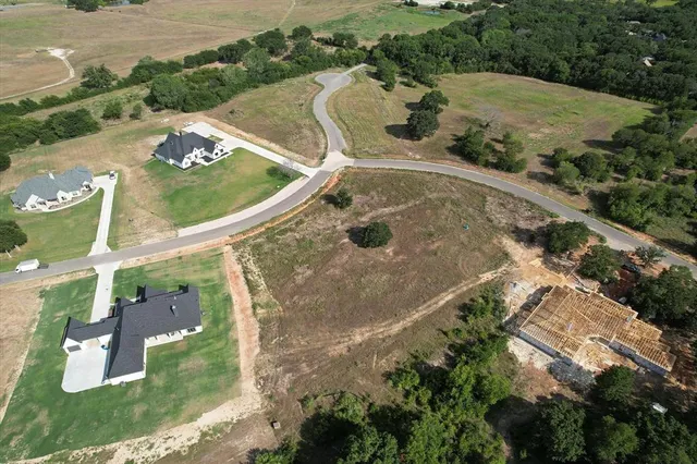 an aerial view of a house with a yard and lake