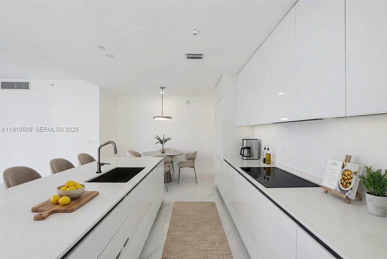 700 Northeast 24th Street, Unit 1101 Miami, FL 33137 - Photo 11 of 66 a kitchen with a sink a counter and appliances