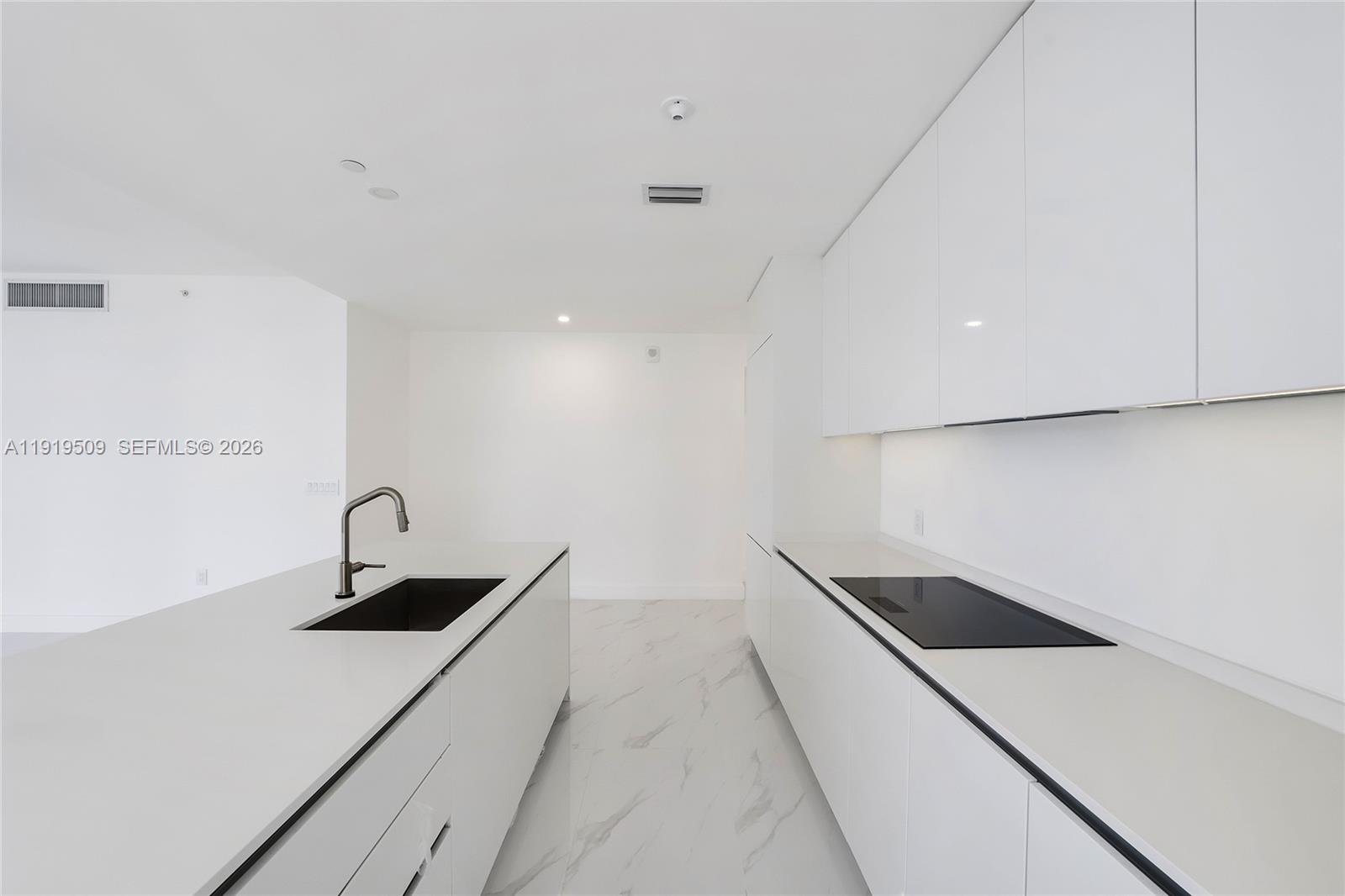 700 Northeast 24th Street, Unit 1101 Miami, FL 33137 - Photo 12 of 66 a kitchen with a sink and white cabinets