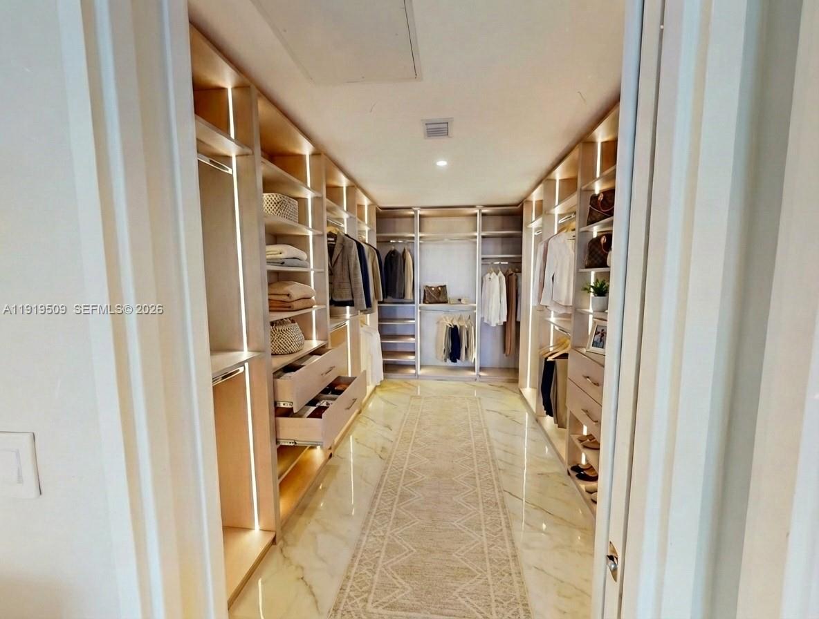 700 Northeast 24th Street, Unit 1101 Miami, FL 33137 - Photo 22 of 66 a view of walk in closet with clothes and shoes