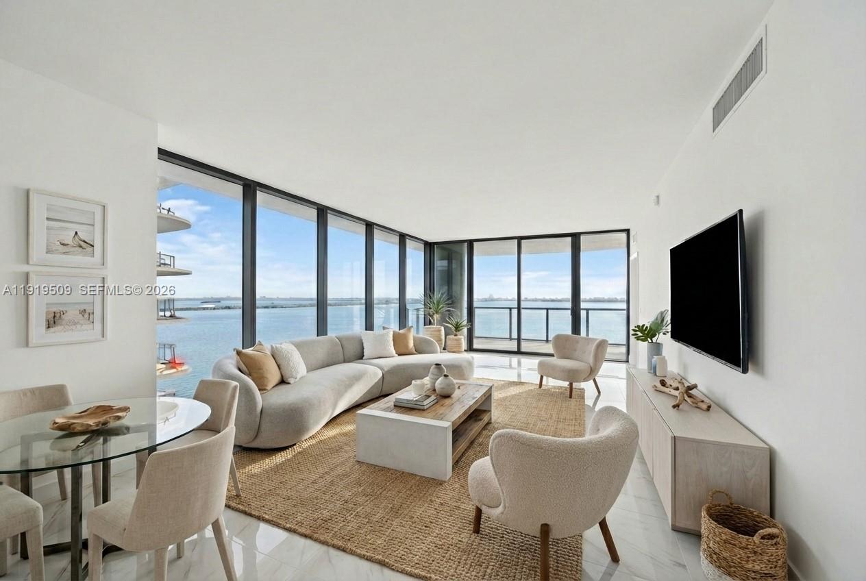 700 Northeast 24th Street, Unit 1101 Miami, FL 33137 - Photo 5 of 66 a living room with furniture a flat screen tv and large windows