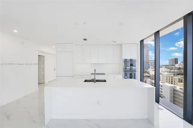 a kitchen with a sink and white cabinets