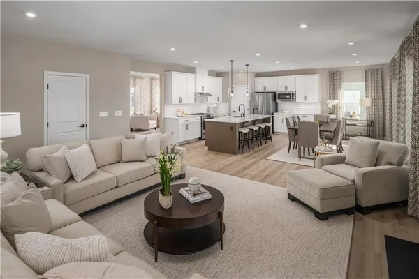 a living room with furniture and a view of kitchen