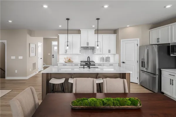 a kitchen with kitchen island stainless steel appliances a sink and cabinets