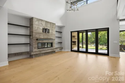 a view of an empty room with a fireplace and a window