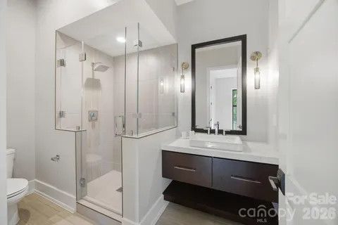 a bathroom with a shower a sink and a mirror