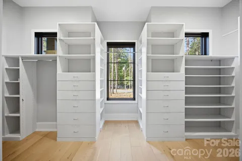 a view of walk in closet with empty racks