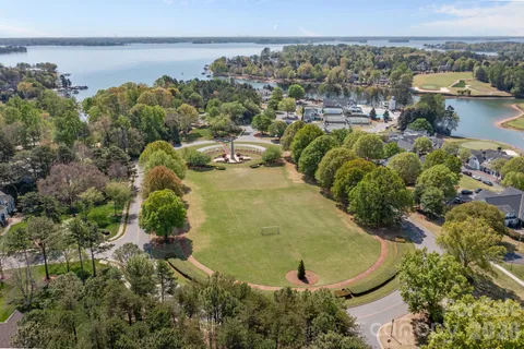 an aerial view of a house with a yard and lake view