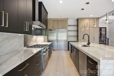 a kitchen with stainless steel appliances granite countertop a sink stove and refrigerator