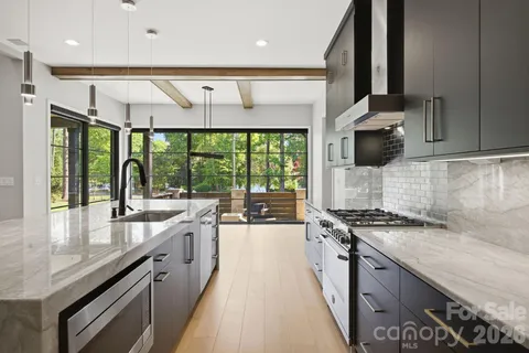 a kitchen with kitchen island granite countertop a sink stove and cabinets