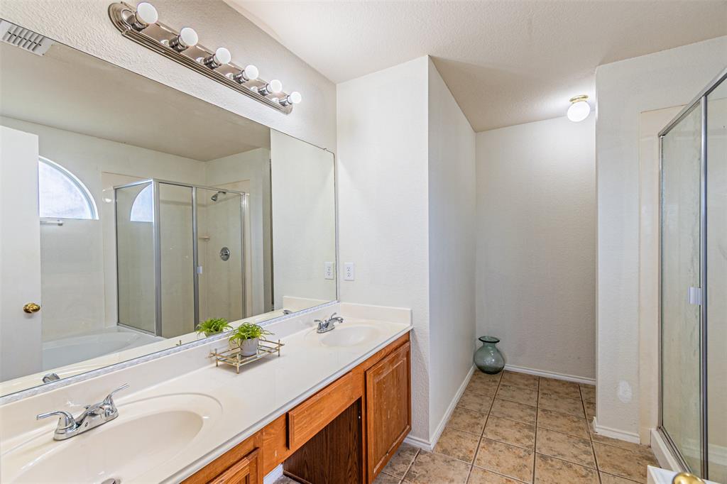 7804 Hidden Path Lane Denton, TX 76210 - Photo 22 of 40 Full bath featuring double vanity, a shower stall, and light tile patterned floors