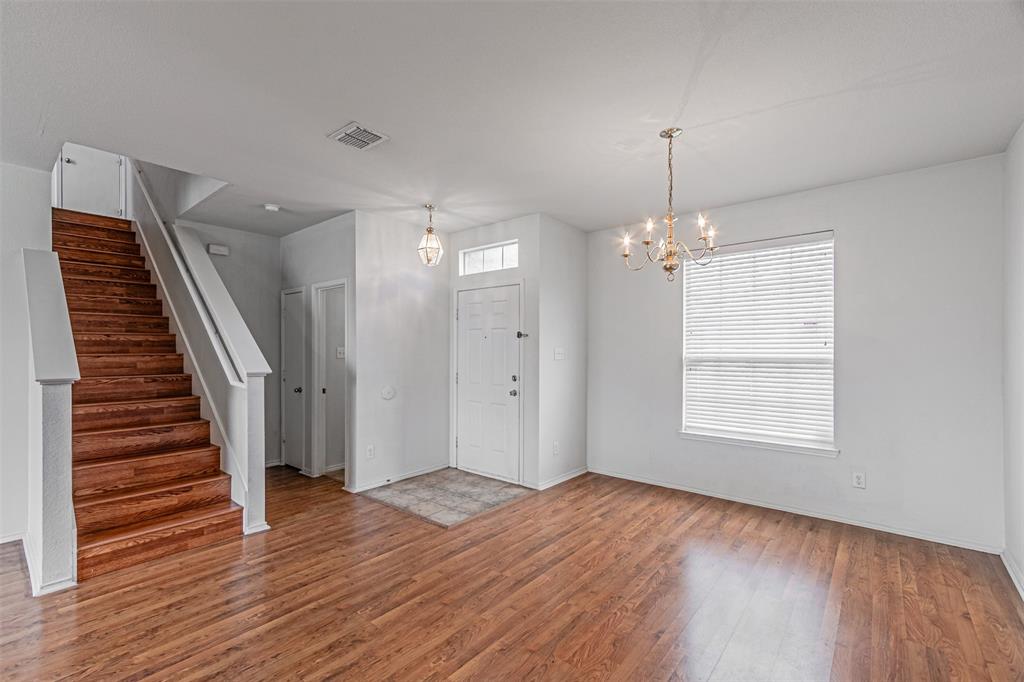 7804 Hidden Path Lane Denton, TX 76210 - Photo 3 of 40 a view of an empty room with wooden floor and a window
