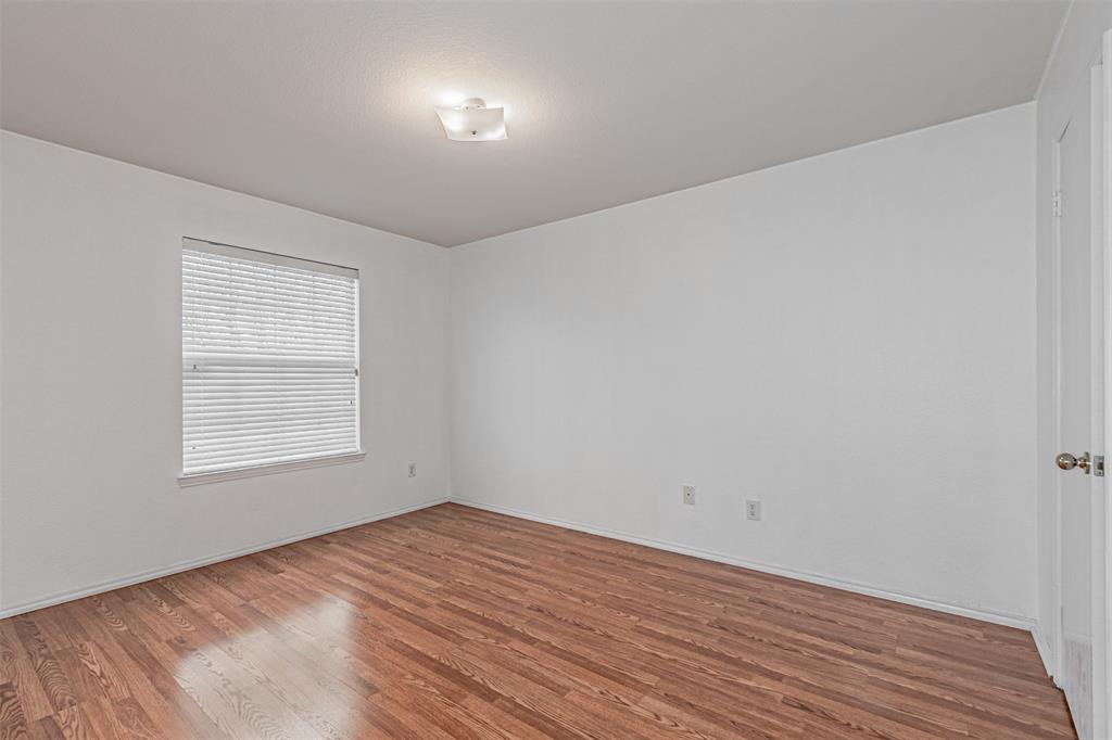 7804 Hidden Path Lane Denton, TX 76210 - Photo 32 of 40 an empty room with wooden floor and windows