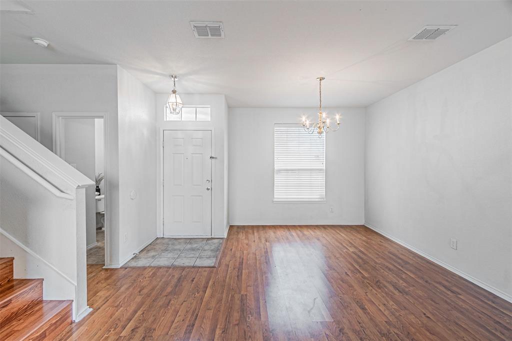 7804 Hidden Path Lane Denton, TX 76210 - Photo 4 of 40 an empty room with wooden floor and windows