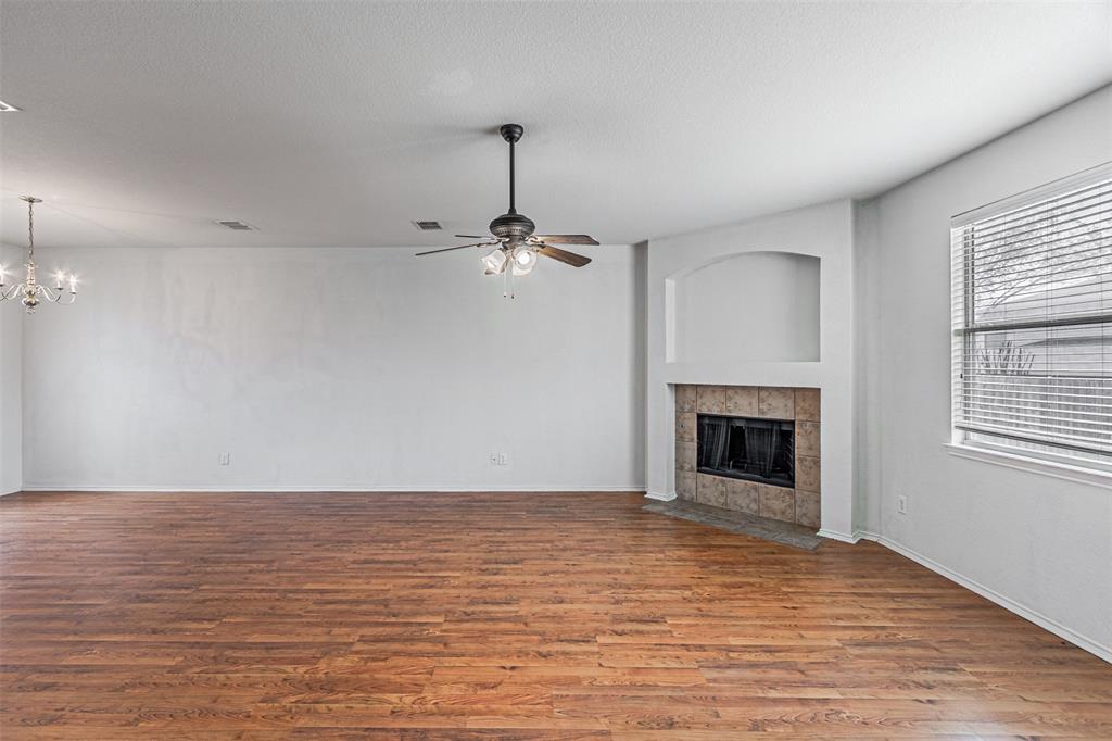7804 Hidden Path Lane Denton, TX 76210 - Photo 7 of 40 an empty room with wooden floor fireplace and windows