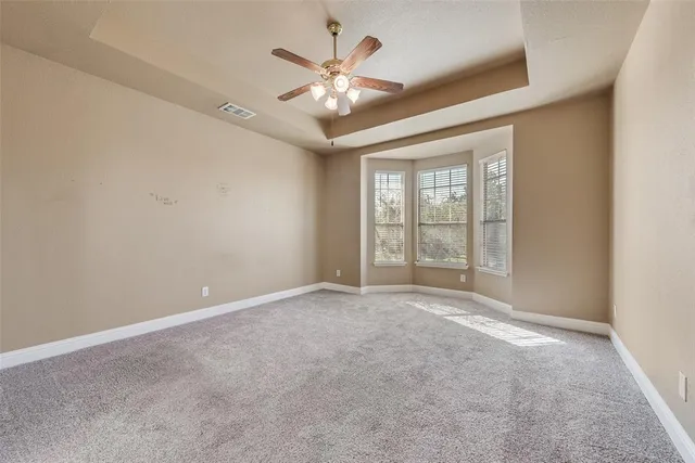 a view of a livingroom with a chandelier fan and windows