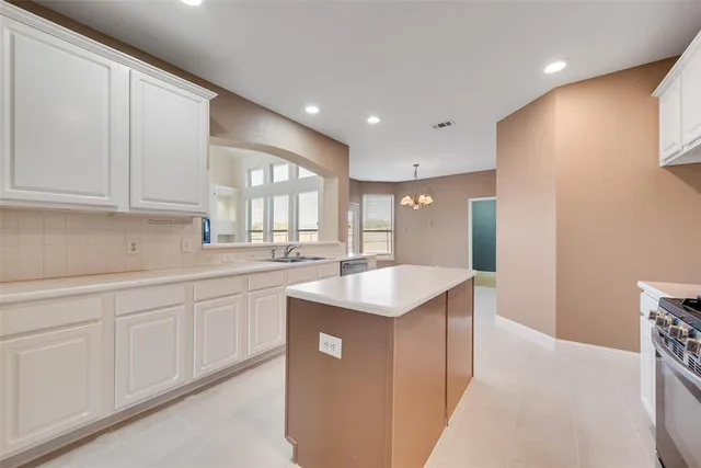 a view of a house with a small yard and a large parking space