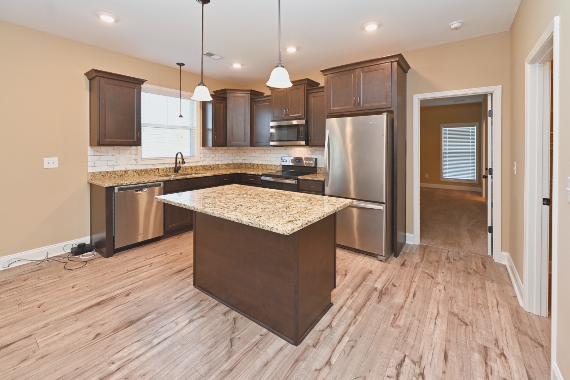 6952 Cainsville Road Lebanon, TN 37090 - Photo 9 of 48 a kitchen with stainless steel appliances granite countertop wooden floor sink and a refrigerator