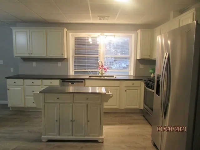 a kitchen with a sink window and refrigerator
