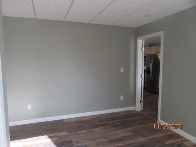 a view of an empty room with wooden floor and closet