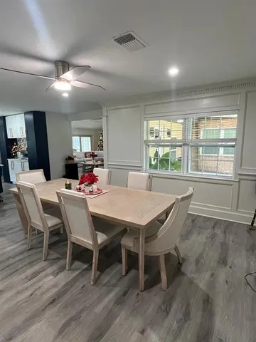 an empty room with a ceiling fan and windows