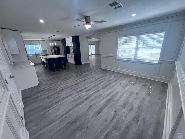 a spacious bedroom with a bed and wooden floor