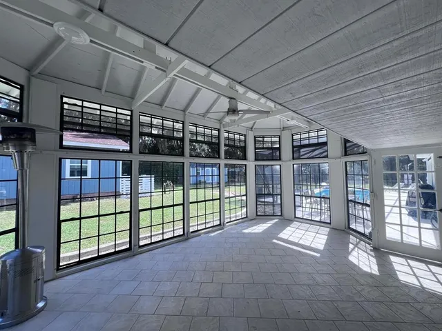 a view of a backyard with a large tree and wooden fence