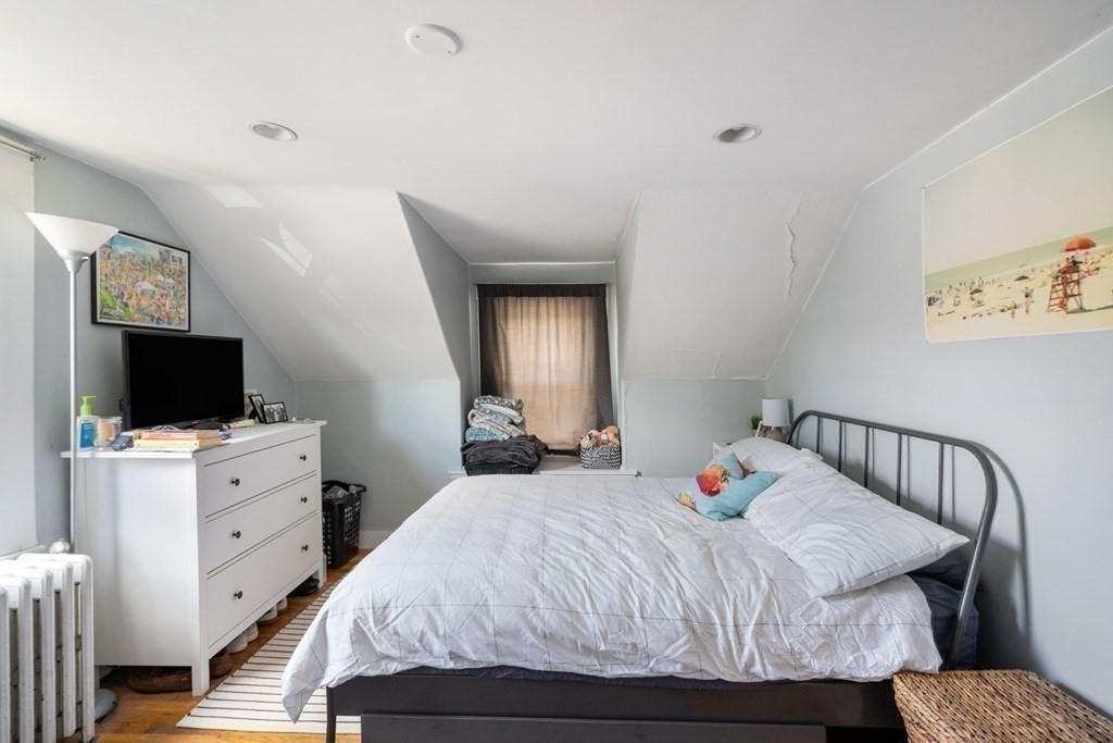1298 Commonwealth Avenue Newton, MA 02468 - Photo 14 of 28 a bedroom with a bed and a flat tv screen on wall