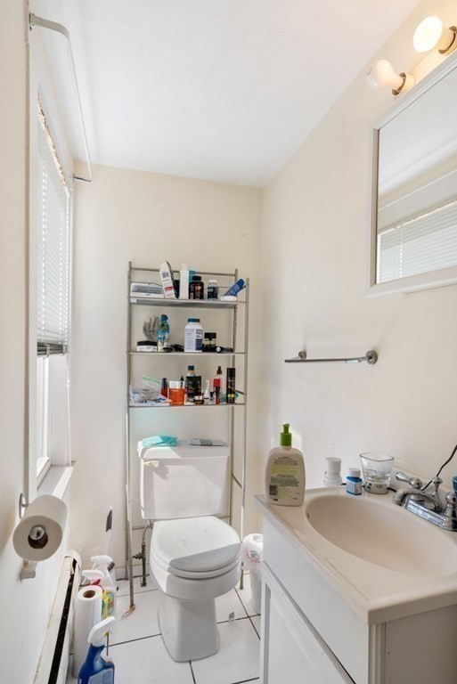 1298 Commonwealth Avenue Newton, MA 02468 - Photo 15 of 28 a bathroom with a granite countertop toilet sink and mirror