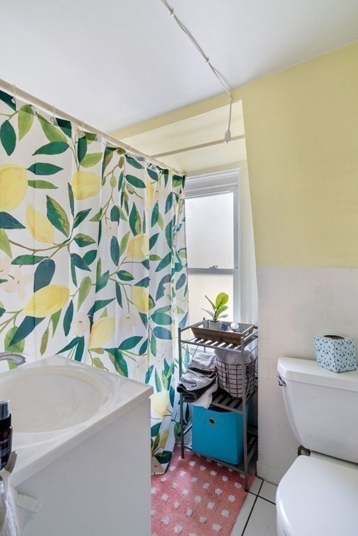 1298 Commonwealth Avenue Newton, MA 02468 - Photo 8 of 28 a bathroom with a sink a toilet and shower curtain