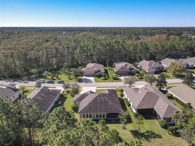 an aerial view of residential houses with outdoor space and lake view