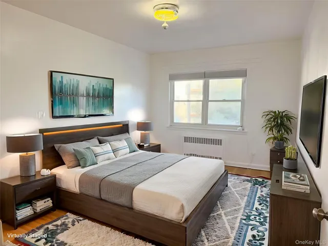 a bedroom with a bed and a flat tv screen on a dresser