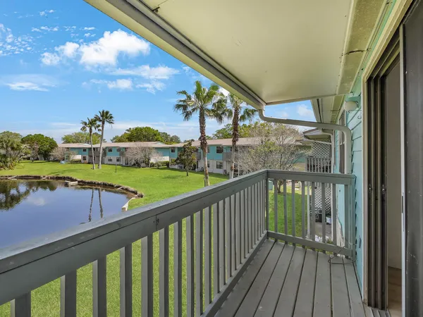 a view of a balcony with wooden floor & fence